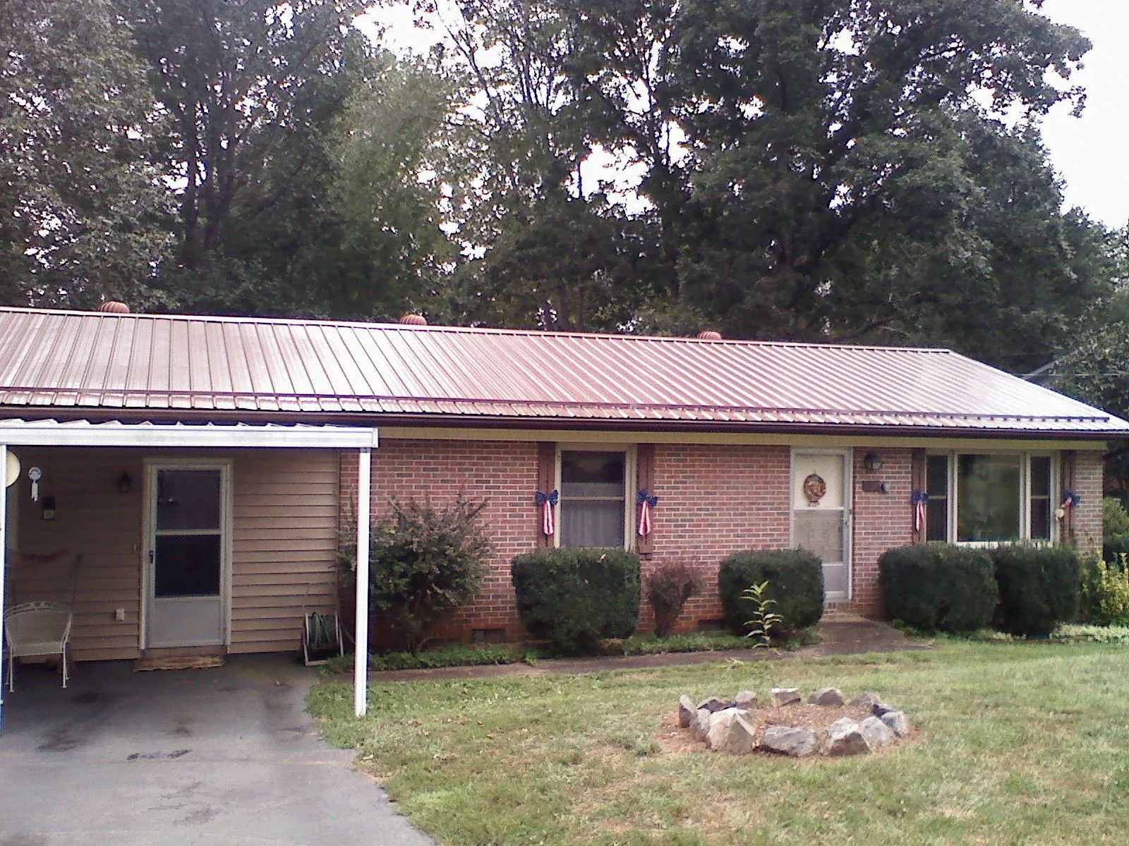 Bronze metal roof and carport on a brick ranch home — Roof Repair work by our crew in Franktown
